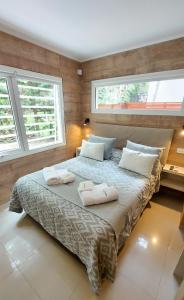 1 dormitorio con 1 cama grande y 2 toallas. en Gala Apart Boutique & Spa -sólo para adultos- en Mar de las Pampas