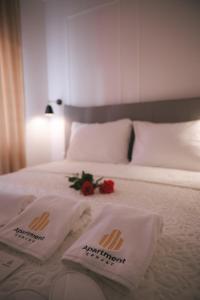 a bed with two towels and a rose on it at Luxury Jacuzzi Apartment in Mostar