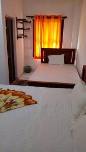 um quarto com uma grande cama branca e uma janela em NIMALA HOLIDAY HOME em Anuradhapura