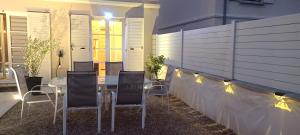 a patio with a table and chairs and lights at Luminary Night Suite in Montévrain