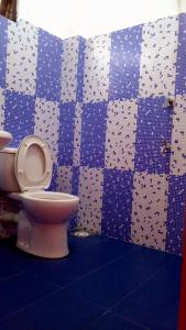 uma casa de banho com WC e azulejos azuis e brancos em NIMALA HOLIDAY HOME em Anuradhapura
