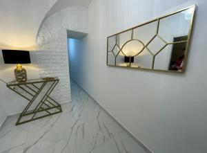 um corredor com uma mesa e um espelho na parede em Real luxury em Nápoles