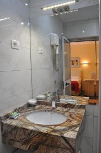 La salle de bains est pourvue d'un lavabo et d'un miroir. dans l'établissement Hotel Pik Loti, à Tirana