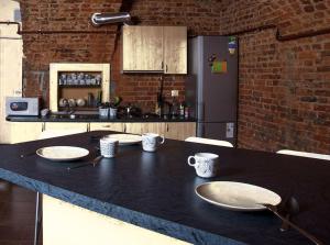 a kitchen with a black counter top with plates on it at Hostel UNDERGROUND in Maribor