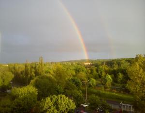 Un arcobaleno nel cielo sopra una città con gli alberi di Apartament Słoneczne Szczecin a Stettino