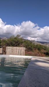 una piscina de agua junto a una valla de madera en Departamento La Trinidad en Merlo