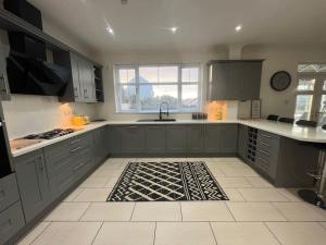 a kitchen with gray cabinets and a kitchen rug at BraeView House in Inverness