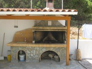 een stenen pizzaoven met een dak bovenop bij Travlos Studios in Póros
