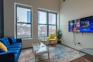 a living room with a blue couch and a tv at McCormick Place 420 friendly 2br/2ba with optional parking for up to 6 guests in Chicago