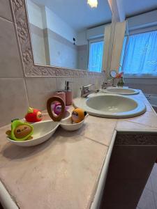 a bathroom counter with two sinks and two bowls of fruit at Cà Savoia in Bologna +10 photos