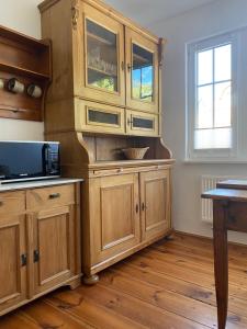 a large wooden cabinet in a kitchen with wooden floors at Ferienwohnung im Dreiseitenhof in Großräschen