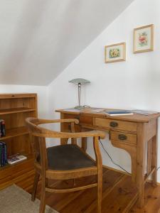 Habitación con escritorio de madera y silla. en Ferienwohnung im Dreiseitenhof, en Großräschen