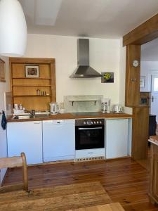 a kitchen with white counters and a stove top oven at Ferienwohnung im Dreiseitenhof in Großräschen