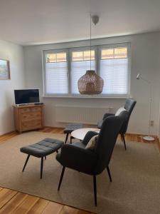 a living room with two chairs and a table at Ferienwohnung im Dreiseitenhof in Großräschen