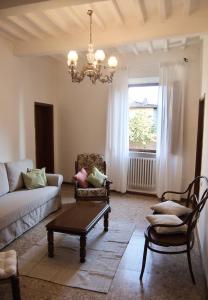 sala de estar con sofá, sillas y lámpara de araña en Casa di Canfreo, en Lari