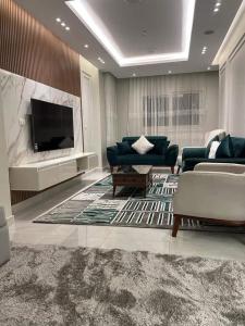 uma sala de estar com sofás e uma televisão de ecrã plano em بورتو السخنه ترحب بكم - Aprag Porto Alsokhna em Suez