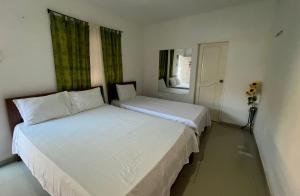 two beds in a small room with two windows at Finca Hotel Villa Manuela in Sahagún