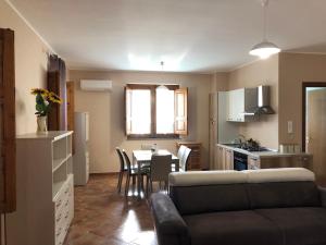 ein Wohnzimmer und eine Küche mit einem Tisch und einem Sofa in der Unterkunft Casa vacanze Mongibello in Milo