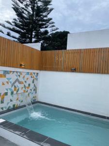 ein Brunnen in einem Schwimmbad mit einem Zaun in der Unterkunft Casa de Santa Catarina - Ponta Delgada in Ponta Delgada