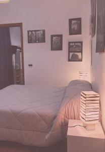 1 dormitorio con 1 cama y 1 mesa con libros en Casa vacanze La Marinella, en SantʼEufemia Lamezia