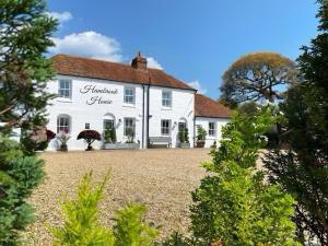 a white house with a large yard in front of it at Hambrook Guest Suites and Private ESPA Spa in Canterbury