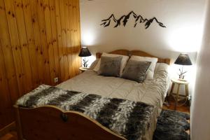 - une chambre avec un lit et un panneau de montagne sur le mur dans l'établissement Appartement cosy montagne, centre ville de Briançon, à Briançon