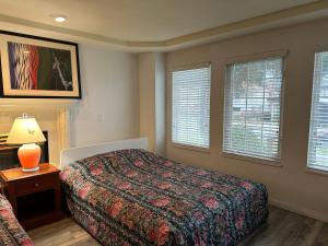 a bedroom with a bed and a lamp and windows at Beautiful Home in Burnaby (Metrotown Area) in Burnaby