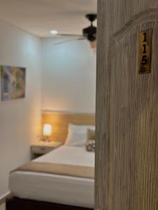 1 dormitorio con 1 cama y un interruptor de luz en la pared en Hotel La Magdalena, en Cartagena de Indias
