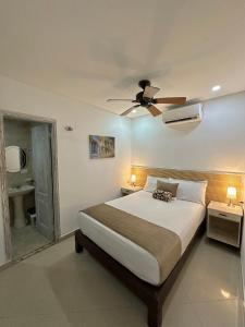 um quarto com uma cama e uma ventoinha de tecto em Hotel La Magdalena em Cartagena das Índias