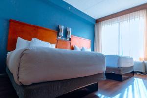 a bedroom with a large bed and a blue wall at Hyatt Place Atlanta Airport North in Atlanta