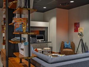 ein Wohnzimmer mit einem blauen Sofa und einem Schreibtisch in der Unterkunft Moxy Phoenix Downtown in Phoenix