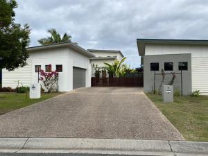 a white house with a driveway in front of it at Little Whale House in Mudjimba