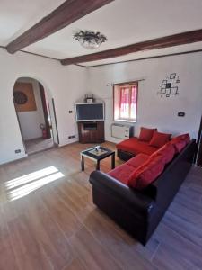 a living room with a red couch and a tv at Chalet di montagna in Trasacco