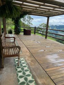 a wooden deck with a bench and a view at Casa do lago com vista linda! - Somente Carro 4x4 ou fazemos translado sem custo in São José dos Campos