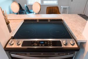 a stove top oven in a kitchen with chairs at Carloover Vista: Mountain Escape in Hot Springs