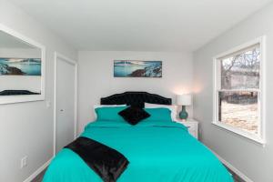 a bedroom with a blue bed in a white room at Carloover Vista: Mountain Escape in Hot Springs