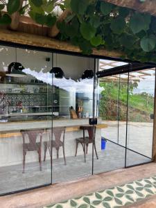 a kitchen with glass doors and a table and chairs at Casa do lago com vista linda! - Somente Carro 4x4 ou fazemos translado sem custo in São José dos Campos