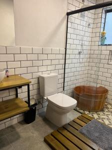 een badkamer met een toilet en een houten bad bij Casa do lago com vista linda! - Somente Carro 4x4 ou fazemos translado sem custo in São José dos Campos