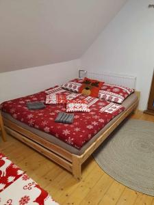 Schlafzimmer mit einem Bett mit roter Bettwäsche und Kissen in der Unterkunft Chata U lesa in Svoboda nad Úpou