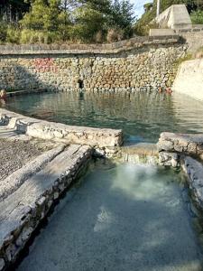 una piscina de agua junto a una pared de piedra en Casa vacanze La Marinella, en SantʼEufemia Lamezia