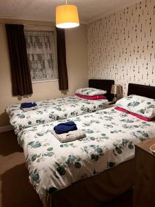 2 camas en un dormitorio con colcha y toallas. en Lynton Hotel, en Blackpool