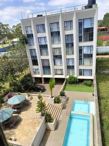 an apartment building with a swimming pool in front of it at Legatus Cozy Homes in Ongata Rongai 