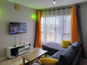 a living room with a couch and a table at Legatus Cozy Homes in Ongata Rongai 