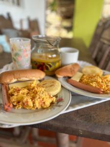 einen Tisch mit zwei Teller Essen und zwei Hot Dogs und Brot in der Unterkunft Cabañas Bellavista La Vega in La Vega