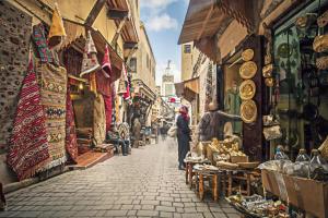 a group of people walking down a street in a market at Fassia in Fez