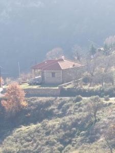 uma casa com um telhado vermelho numa colina em Chalet Vella 