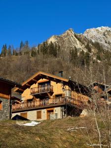 ein großes Haus mit einem Balkon und einem Berg in der Unterkunft Le Refuge d'Ours, Champagny in Champagny-en-Vanoise