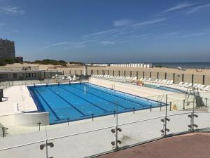 a swimming pool on top of a building next to the beach at Skyview Suite in Oostduinkerke