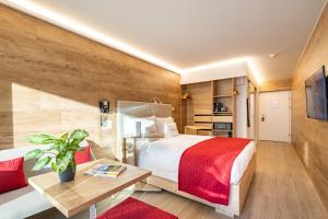 a hotel room with a large bed and a table at Hotel Sonne St. Moritz 3* Superior in St. Moritz