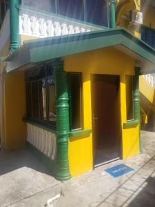a lego house with a yellow and green building at Mandy's Homestay in Couva